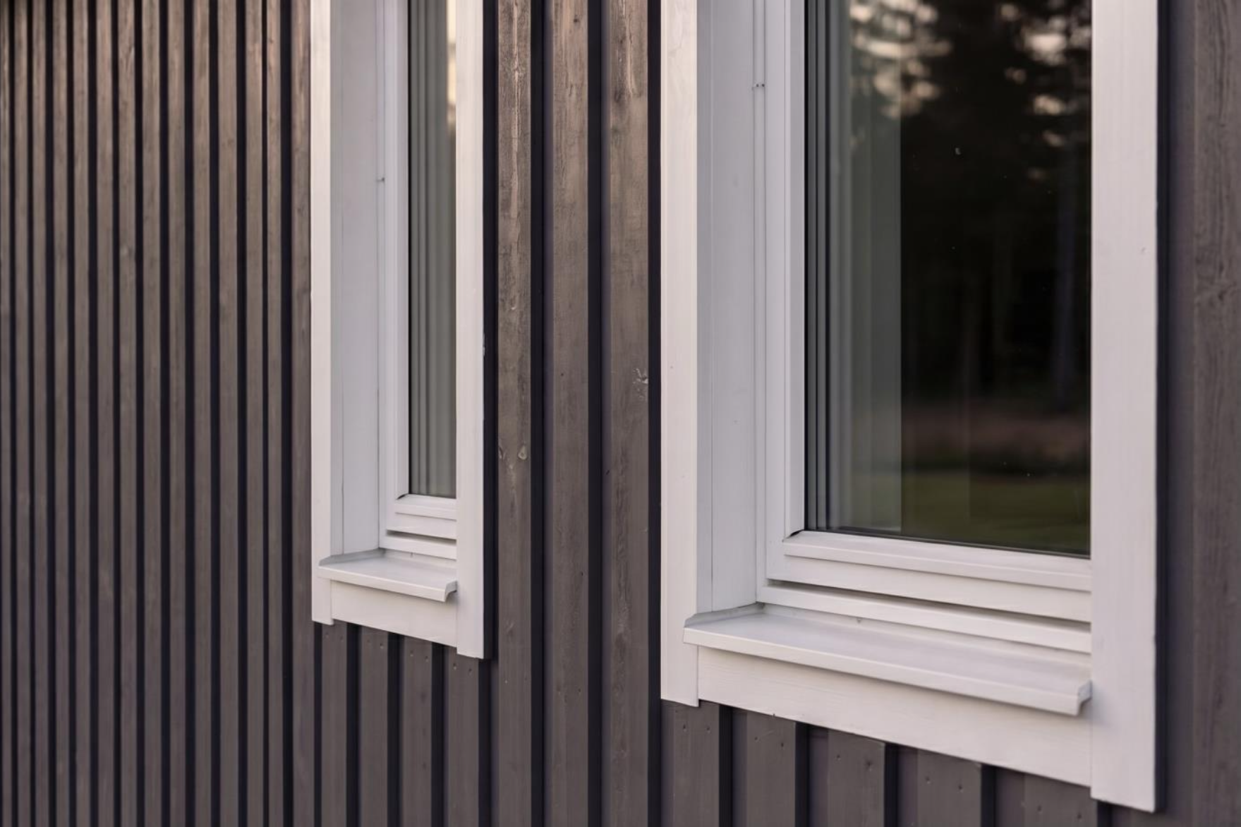Närbild på fönsterfoder och stående träpanel i kvällsljus